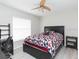 Bedroom featuring a modern ceiling fan, a large window, and a workspace with a desk at 23635 Oakside Blvd, Lutz, FL 33559