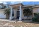 Tan one-story home with a front porch and palm trees at 2365 Ardenwood Dr, Spring Hill, FL 34609