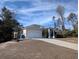 Tan one-story house with a white garage door at 2365 Ardenwood Dr, Spring Hill, FL 34609