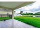 Covered patio overlooking a grassy backyard and a pond at 3533 Juneberry Drive, Wesley Chapel, FL 33543