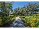 Landscaped walking path with yellow flowers and shade trees at 417 Brandywine Falls Ct, Apollo Beach, FL 33572