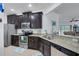 Modern kitchen with dark wood cabinets, granite counters, and stainless steel appliances at 417 Brandywine Falls Ct, Apollo Beach, FL 33572