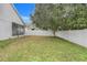 Grass backyard with white fence and a tree at 4605 Lisette Cir, Brooksville, FL 34604