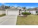 House exterior featuring a two-car garage and well-manicured lawn at 4605 Lisette Cir, Brooksville, FL 34604