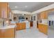 Open kitchen boasts wood cabinets, tile flooring, and a view into the adjacent living area at 4605 Lisette Cir, Brooksville, FL 34604