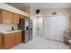 Kitchen features stainless steel refrigerator, wood cabinets, and pantry access at 4605 Lisette Cir, Brooksville, FL 34604