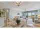 Dining room with glass table, white chairs and view into living room at 4900 Brittany S Dr # 701, St Petersburg, FL 33715