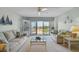 Living room with striped couches, coffee table, and balcony access at 4900 Brittany S Dr # 701, St Petersburg, FL 33715