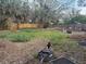 Overgrown backyard with wood fence and wheelbarrow at 4933 Venetian Ne Blvd, St Petersburg, FL 33703
