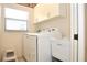 Bright laundry room with washer, dryer, and cabinets at 5581 Salem Square S Dr, Palm Harbor, FL 34685
