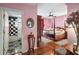 Bedroom with pink walls, hardwood floors, and a four-poster bed at 608 Columbus Dr, Tierra Verde, FL 33715