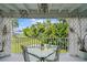 Covered deck with glass-top table and chairs, offering a scenic view at 608 Columbus Dr, Tierra Verde, FL 33715