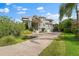 Grand home featuring a brick driveway and palm trees at 608 Columbus Dr, Tierra Verde, FL 33715