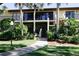 Two-story condo building with lush landscaping and walkway at 6472 Seagull Dr # 303, Bradenton, FL 34210