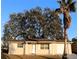 Tan house with attached garage, and large oak tree in front yard at 9116 Chantilly Ln, Port Richey, FL 34668