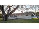 Tan house with sunroom and large oak tree at 9116 Chantilly Ln, Port Richey, FL 34668