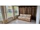 Sunroom with tiled floor, sofa and window curtains at 9116 Chantilly Ln, Port Richey, FL 34668