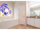Spa-like bathroom with a large soaking tub, stained glass window, and updated vanity at 23635 Oakside Blvd, Lutz, FL 33559
