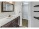 Bathroom with dark vanity, a large mirror and access to a closet at 11201 122Nd Ave # 204, Largo, FL 33778