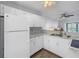 White kitchen with stainless steel appliances and wood floors at 11201 122Nd Ave # 204, Largo, FL 33778