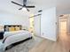 Main bedroom with king-size bed, barn door, and light wood floors at 2058 Sheffield Ct, Oldsmar, FL 34677