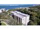 Aerial view of a condo building with water access and lush landscaping at 220 Belleview Blvd # 609, Belleair, FL 33756