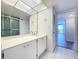 Bright bathroom with white vanity, double sinks, and a large mirror at 220 Belleview Blvd # 609, Belleair, FL 33756
