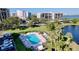 Community pool with lounge chairs and surrounding green space at 220 Belleview Blvd # 609, Belleair, FL 33756