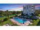 Resort-style pool and surrounding patio area with adjacent building at sunset at 220 Belleview Blvd # 609, Belleair, FL 33756