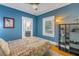 Bedroom with blue walls, hardwood floors, and a patterned comforter at 236 9Th Ne Ave, St Petersburg, FL 33701
