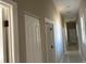 Long hallway with light walls and white doors at 3040 Sheppards Crook Ct, Holiday, FL 34691
