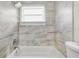 Bathroom with a bathtub and gray marble-look tile at 3145 Covina St, New Port Richey, FL 34655