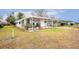 Landscaped yard with a white mobile home and covered carport at 37318 Lois Ave, Zephyrhills, FL 33542