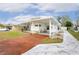 White mobile home with a carport and landscaped yard at 37318 Lois Ave, Zephyrhills, FL 33542