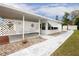 White mobile home with a covered patio and a lattice fence at 37318 Lois Ave, Zephyrhills, FL 33542