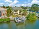 Waterfront backyard with a private dock, boat lift, and a lush lawn with outdoor seating, ideal for entertaining and enjoying the water at 808 Symphony Isles Blvd, Apollo Beach, FL 33572