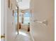 Hallway view leading to a luxurious bathroom with a soaking tub, natural light, and elegant finishes at 808 Symphony Isles Blvd, Apollo Beach, FL 33572