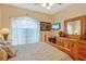 Comfortable bedroom features hardwood floors, ceiling fan, and a large bed with decorative pillows at 808 Symphony Isles Blvd, Apollo Beach, FL 33572
