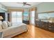 Well-lit bedroom with a comfortable bed, dark wood furniture, and large windows for natural light at 808 Symphony Isles Blvd, Apollo Beach, FL 33572