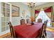 Formal dining room with chandelier, large dining table, red tablecloth and french door views at 808 Symphony Isles Blvd, Apollo Beach, FL 33572