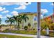 Bright two-story home with lush landscaping and mature palm trees at 808 Symphony Isles Blvd, Apollo Beach, FL 33572