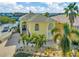 Elegant two-story home with a lushly landscaped yard and decorative palm trees, offering a grand entrance and curb appeal at 808 Symphony Isles Blvd, Apollo Beach, FL 33572