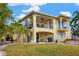 Two-story home with backyard patio, outdoor grill, spiral staircase, and well-manicured lawn at 808 Symphony Isles Blvd, Apollo Beach, FL 33572