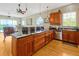 Bright kitchen boasts stainless steel appliances, wood cabinets, and granite countertops, flowing into the living room at 808 Symphony Isles Blvd, Apollo Beach, FL 33572
