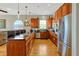 Open kitchen with a spacious granite island, stainless steel appliances, and hardwood floors at 808 Symphony Isles Blvd, Apollo Beach, FL 33572