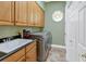 Convenient laundry room with a utility sink, washer and dryer, and ample storage space at 808 Symphony Isles Blvd, Apollo Beach, FL 33572