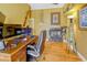 Well-lit home office with a fireplace, wood floors, wooden propeller, and yellow walls at 808 Symphony Isles Blvd, Apollo Beach, FL 33572