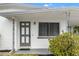 Front door entrance with grey door and white exterior at 10233 108Th Ave, Largo, FL 33773