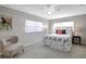 Main bedroom with gray walls, floral bedding, and ceiling fan at 10926 N Lantana Ave, Tampa, FL 33612