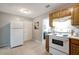 Efficient kitchen with wood cabinets and white appliances at 10926 N Lantana Ave, Tampa, FL 33612